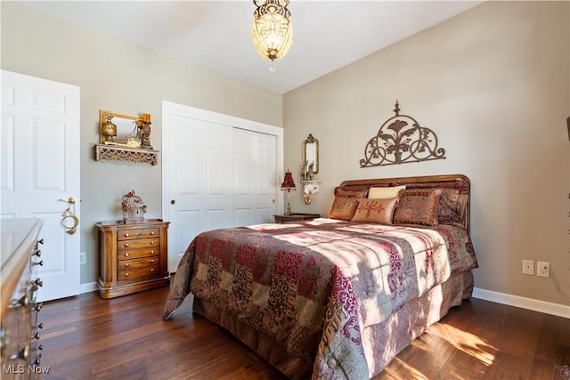 bedroom with a closet, baseboards, and wood finished floors