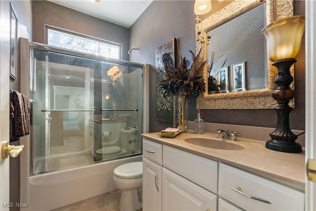 bathroom featuring tile patterned floors, enclosed tub / shower combo, toilet, and vanity