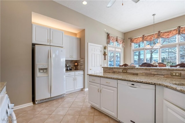 kitchen with white appliances, light tile patterned floors, decorative backsplash, hanging light fixtures, and white cabinetry