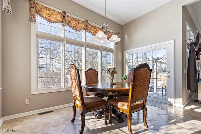 dining area featuring light tile patterned flooring, baseboards, visible vents, and a healthy amount of sunlight