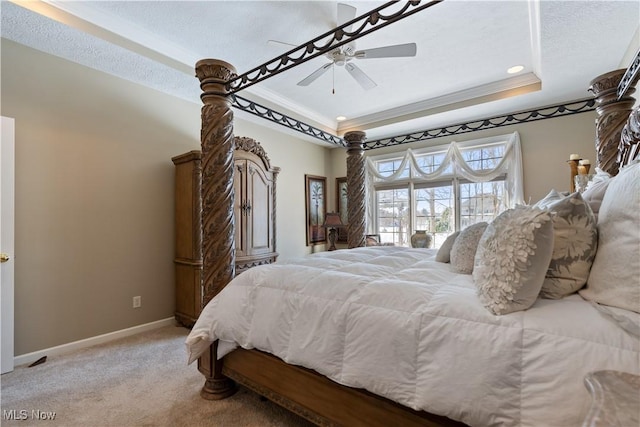 bedroom with a tray ceiling, carpet flooring, baseboards, and ornamental molding