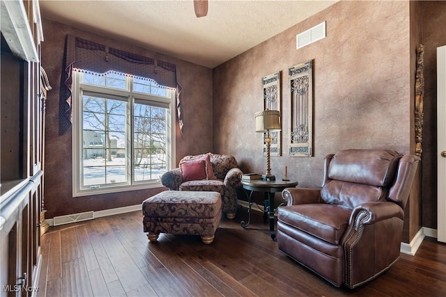 sitting room featuring hardwood / wood-style floors, baseboards, visible vents, and a textured ceiling