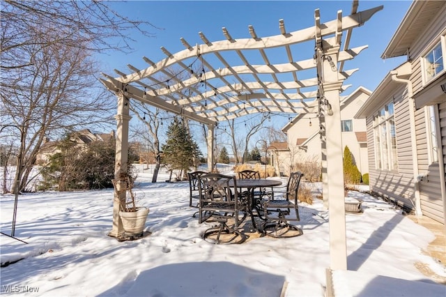 snow covered patio featuring outdoor dining space and a pergola