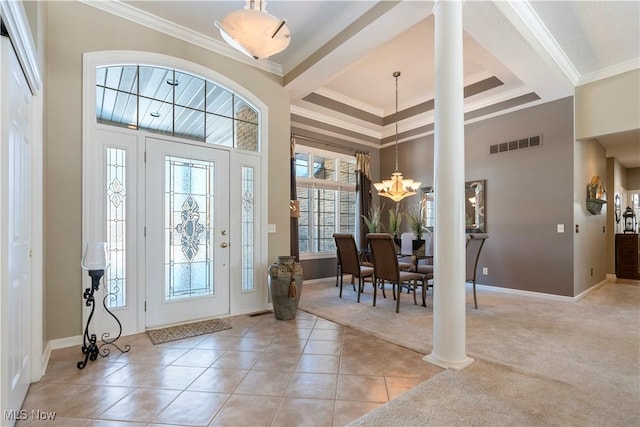 foyer entrance featuring visible vents, a notable chandelier, light tile patterned flooring, and ornamental molding