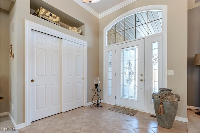 entryway featuring light tile patterned floors, baseboards, and ornamental molding