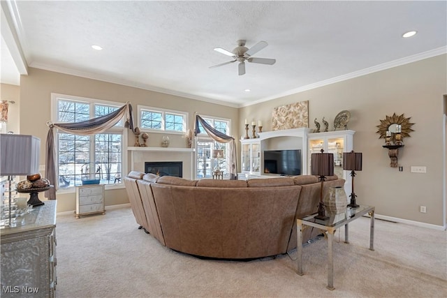 living room featuring baseboards, light colored carpet, a glass covered fireplace, and crown molding