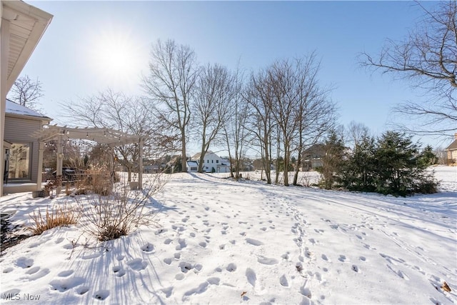 snowy yard with a pergola