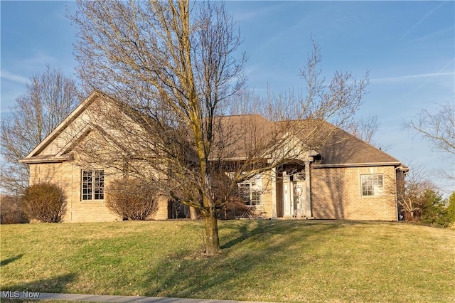 single story home featuring a front yard and brick siding