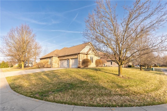 view of front of home featuring an attached garage, driveway, and a front lawn