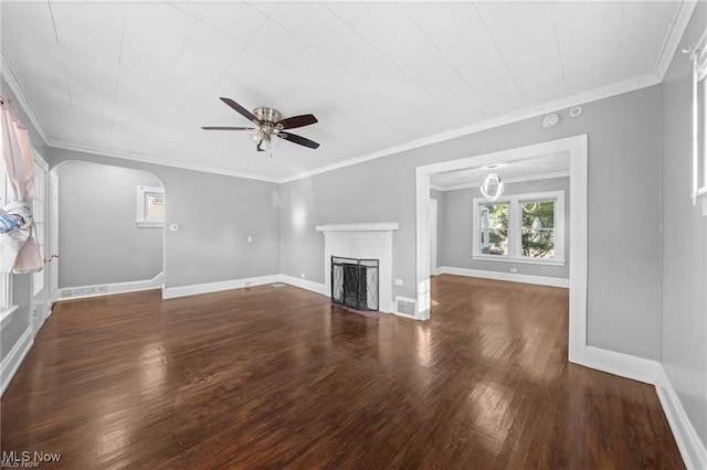 unfurnished living room with baseboards, arched walkways, wood finished floors, and a fireplace