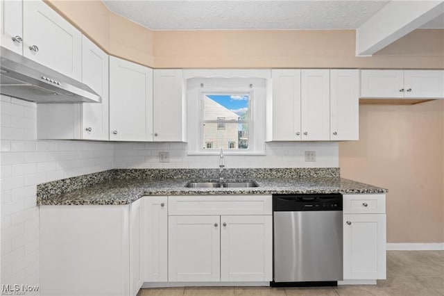 kitchen with dark stone counters, a sink, under cabinet range hood, stainless steel dishwasher, and backsplash