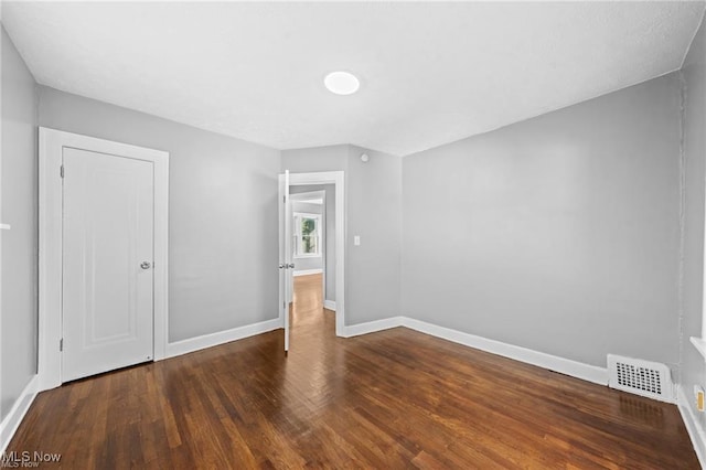 unfurnished bedroom with visible vents, baseboards, and wood finished floors