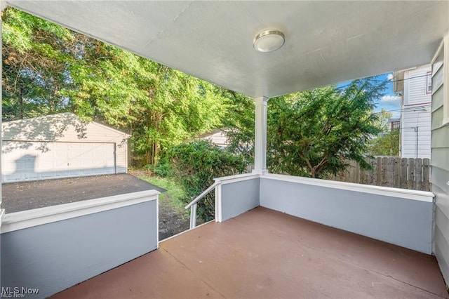 view of patio featuring an outbuilding, fence, and a detached garage