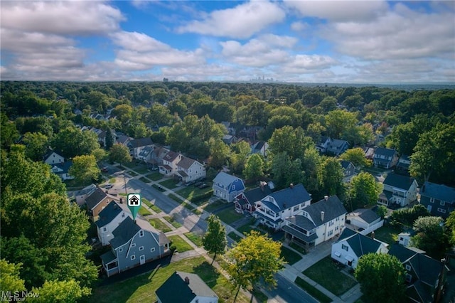 drone / aerial view featuring a residential view and a wooded view