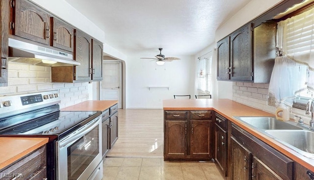 kitchen featuring ceiling fan, a sink, light countertops, electric stove, and under cabinet range hood