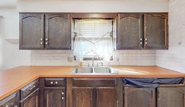 kitchen with a sink, dark brown cabinetry, and light countertops