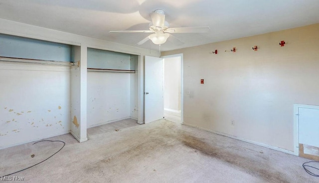 unfurnished bedroom featuring baseboards, multiple closets, and ceiling fan