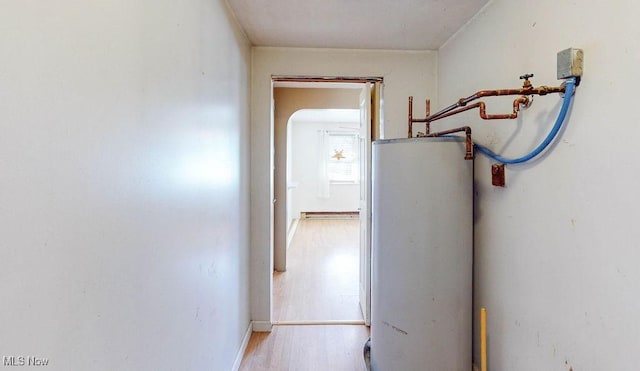 hall featuring water heater, a baseboard heating unit, and wood finished floors