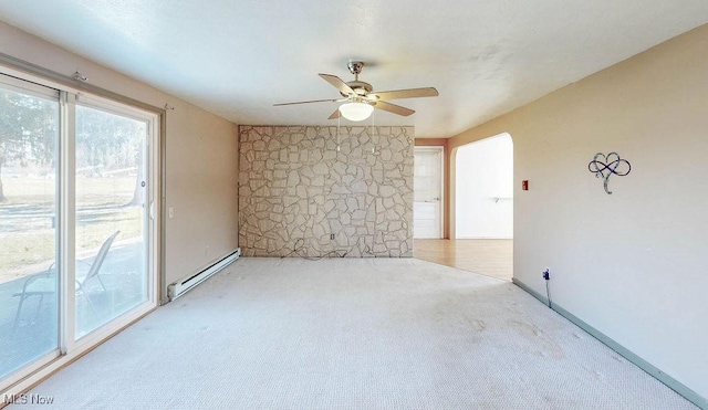 empty room with carpet flooring, a ceiling fan, baseboards, and baseboard heating