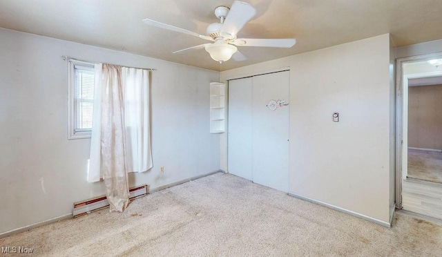 unfurnished bedroom featuring a baseboard heating unit, a closet, ceiling fan, and carpet flooring