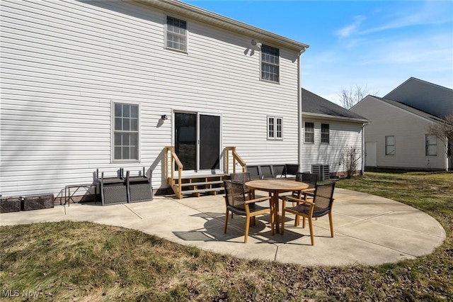 rear view of house with a lawn, entry steps, and a patio