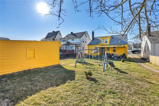 view of yard with a residential view, a playground, and fence