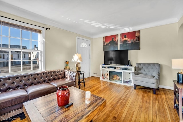 living area with baseboards and light wood finished floors