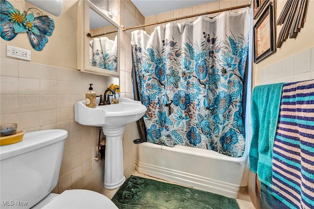 bathroom featuring toilet, tile walls, and shower / tub combo with curtain