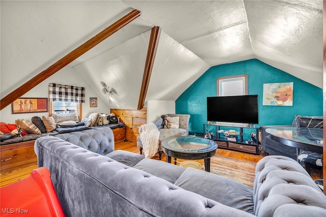 living room featuring lofted ceiling and wood finished floors