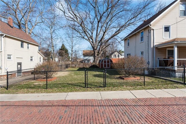 view of yard with an outbuilding, a storage unit, and fence private yard