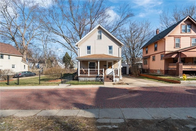 view of front of house featuring a fenced front yard, covered porch, and decorative driveway