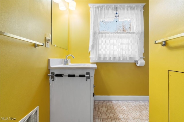 bathroom featuring vanity, baseboards, and visible vents