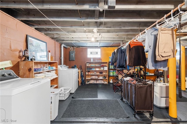 below grade area featuring washer and dryer, electric panel, and concrete block wall