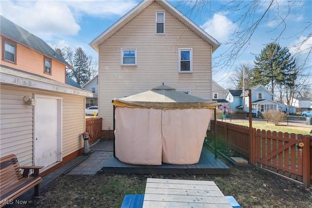 rear view of property with a deck and fence