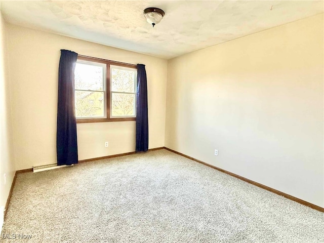 carpeted spare room with baseboards