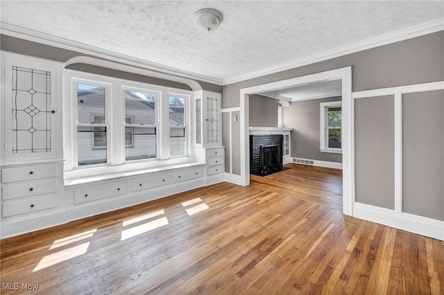 12117 Craven Ave, Cleveland, OH 44105 - unfurnished living room with a textured ceiling, ornamental molding, light wood finished floors, a fireplace with flush hearth, and baseboards