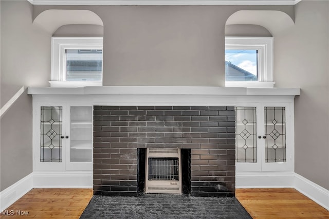 12117 Craven Ave, Cleveland, OH 44105 - detailed view of heating unit, wood finished floors, a fireplace, baseboards, and arched walkways