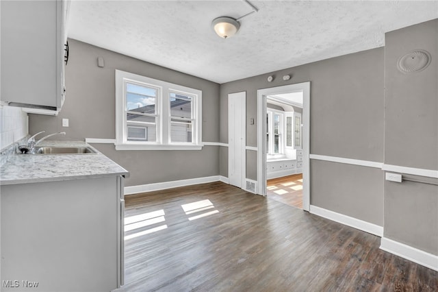 12117 Craven Ave, Cleveland, OH 44105 - unfurnished dining area with a sink, wood finished floors, baseboards, and a textured ceiling