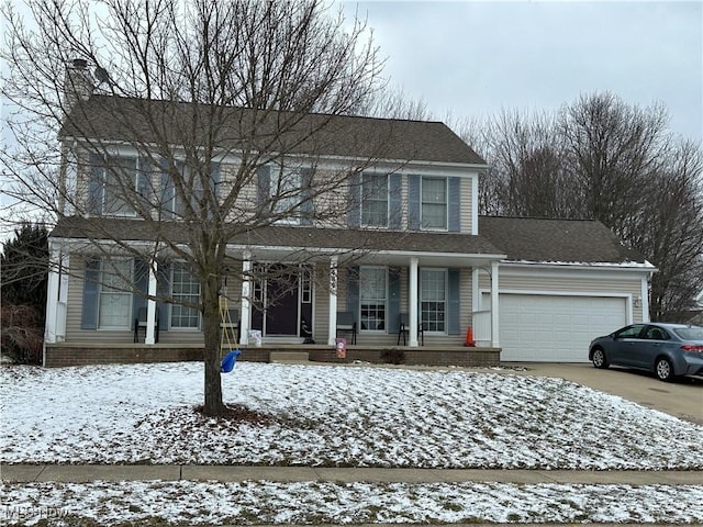 colonial inspired home featuring a garage, covered porch, and concrete driveway