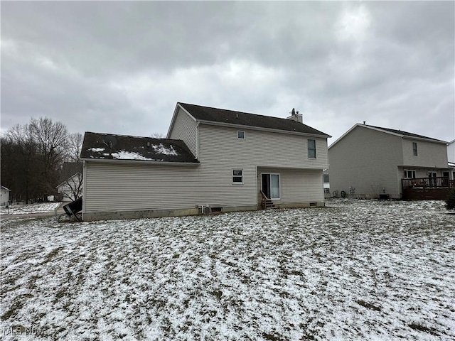 view of snow covered back of property