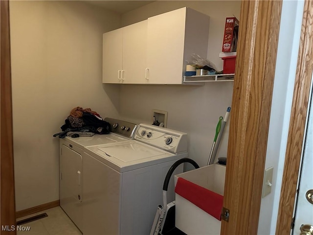 laundry room with washer and clothes dryer, a sink, cabinet space, light tile patterned floors, and baseboards