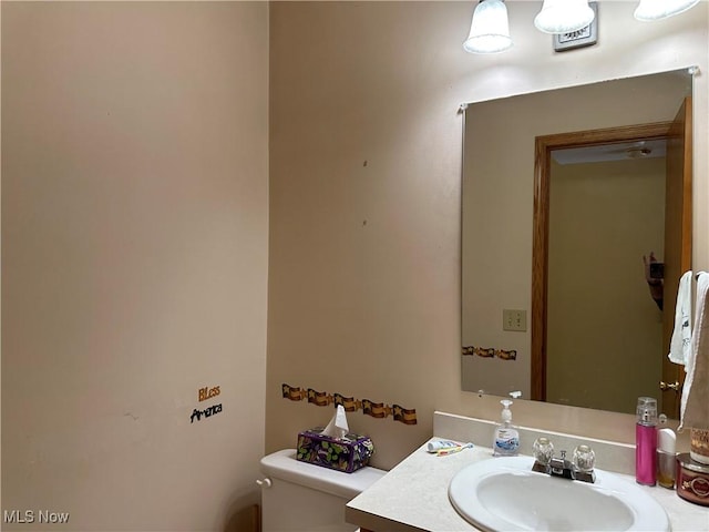 half bathroom with toilet and vanity