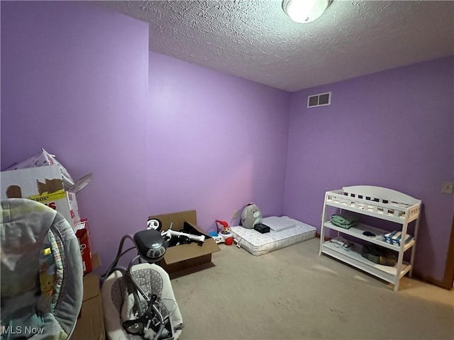 carpeted bedroom with visible vents and a textured ceiling