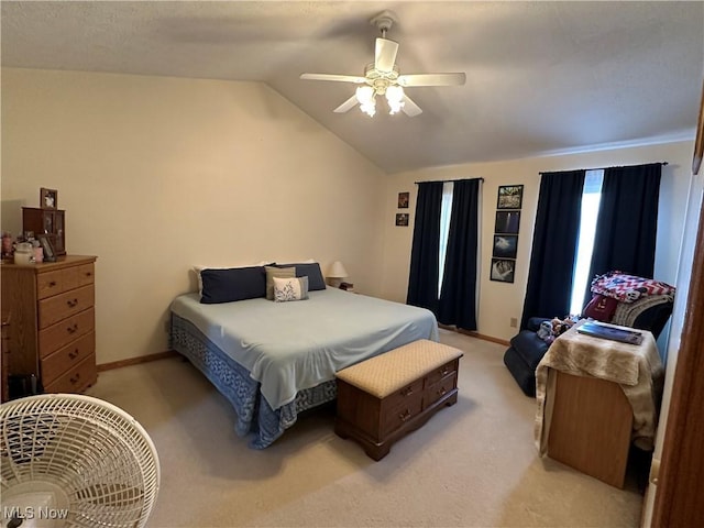 bedroom with a ceiling fan, vaulted ceiling, light colored carpet, and baseboards