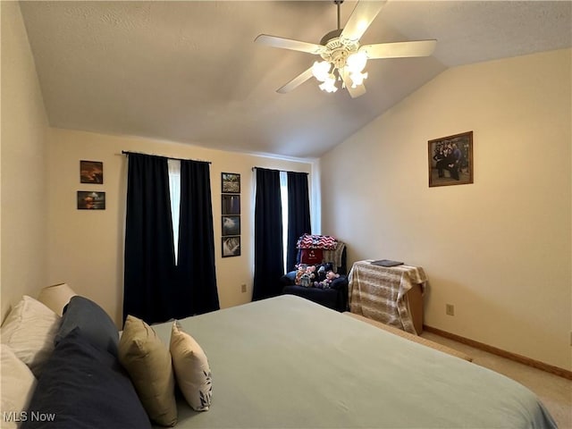 carpeted bedroom featuring baseboards, lofted ceiling, and ceiling fan