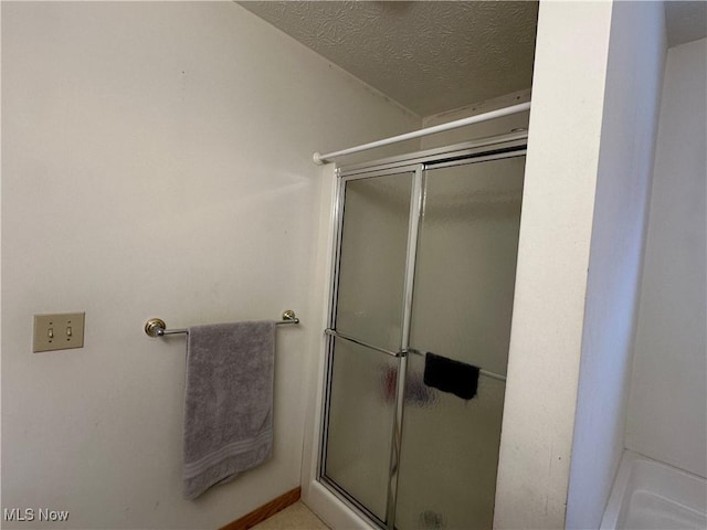 full bath with a stall shower and a textured ceiling