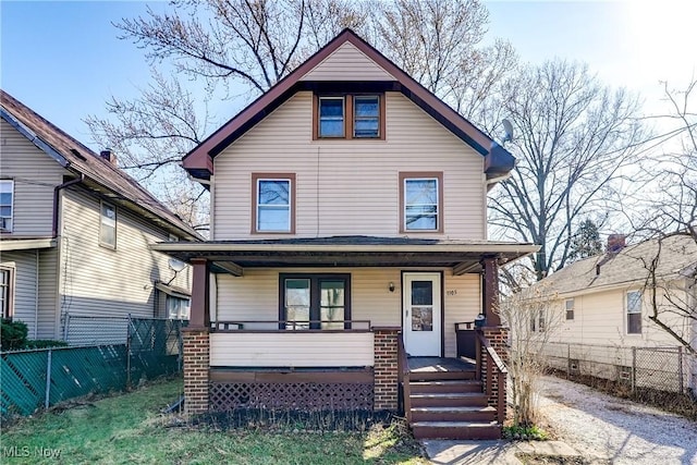 american foursquare style home with a porch and fence