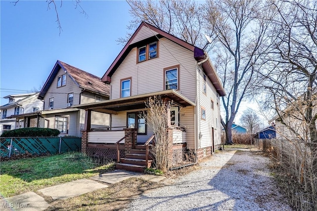 traditional style home featuring fence, covered porch, and driveway