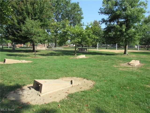 view of home's community featuring volleyball court and a lawn