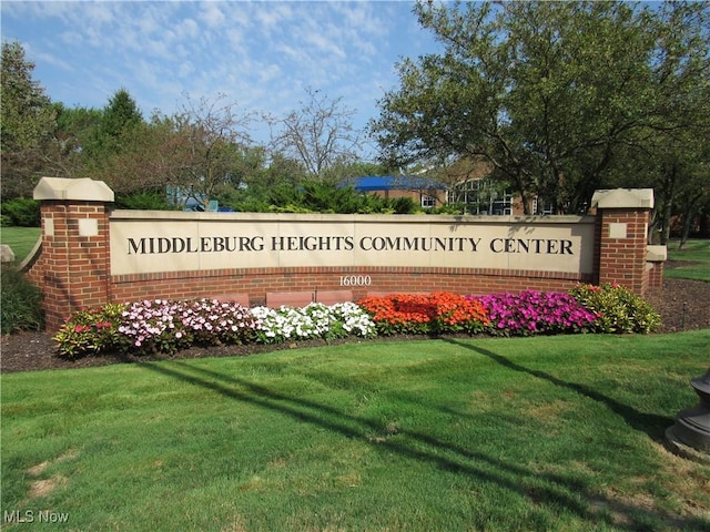 community / neighborhood sign with a yard